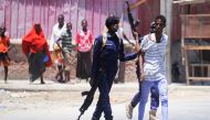 Somali soldiers arrest a civilian close to the scene of two explosions set off near the ministries of public works and labour in Mogadishu on March 23, 2019. AFP / MOHAMED ABDIWAHAB
