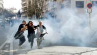 Protesters run away as tear gas is fired during 19th round of 