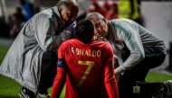 Doctors check on Portugal's forward Cristiano Ronaldo during the Euro 2020 qualifying group B football match between Portugal and Serbia at the Luz stadium in Lisbon on March 25, 2019. / AFP / PATRICIA DE MELO MOREIRA