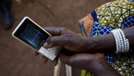 Esther Nakisige, a beneficiary of the MUIIS farmer information service, checks her phone at her home in Iganga District, Uganda, on February 14, 2019. Thomson Reuters Foundation