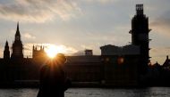 A man stands on the banks of River Thames, across from the Houses of Parliament in Westminster, in central London on March 27, 2019.  AFP / Tolga Akmen 