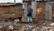 A child stands behind pit latrines made of rusted iron sheets in Kibera slum within Nairobi, Kenya February 24, 2019. Reuters/Njeri Mwangi