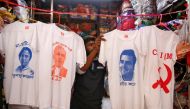 A worker displays T-shirts with images of (L-R) Chief Minister of West Bengal state Mamata Banerjee, Prime Minister Narendra Modi, India's main opposition Congress party Chief Rahul Gandhi and logo of Communist Party of India (Marxist) CPI (M), for sale i