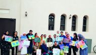 Participants with their paintings at an art workshop with the theme ‘Nature and Environment’ at Katara Art Studio.