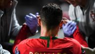 FILE PHOTO: Portugal's forward Cristiano Ronaldo is attended by doctors during the Euro 2020 qualifying group B football match between Portugal and Serbia at the Luz stadium in Lisbon on March 25, 2019. / AFP / PATRICIA DE MELO MOREIRA