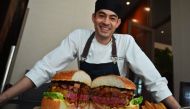 Patrick Shimada, the chef de cuisine at The Oak Door of the Grand Hyatt Tokyo hotel poses with a 3kgs burger in Tokyo on April 1, 2019.  AFP / Charly Triballeau 