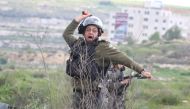 An israeli soldier throws tear gas at Birzeit University students during a protest after Israeli forces take 3 students into custody, near Beit Il Israeli military check point in Ramallah, West Bank on March 27, 2019. (?ssam Rimawi/Anadolu Agency)
 
