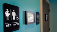 Unisex signs hanging outside bathrooms at Toast Paninoteca in Durham North Carolina, May 9, 2016.  AFP/Getty Images North America/Sara D Davis