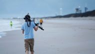 A visitor arrives at sunrise at Playalinda Beach, just north of the Kennedy Space Center in Florida, to find a good vantage point on April 10, 2019.  AFP / Gregg Newton 
