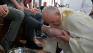 Pope Francis kisses an inmate's foot as he washes the feet of inmates at the Velletri prison, south of Rome, during the Holy Thursday celebrations on April 18, 2019. AFP/Vatican Media