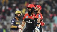 Royal Challengers Bangalore's cricketers Moeen Ali and Virat Kohli (R) celebrate as Kolkata Knight Riders's captain Dinesh Karthik(L) looks on during the 2019 Indian Premier League (IPL) Twenty 20 cricket match between Kolkata Knight Riders and Royal Chal
