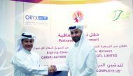 The officials of QAS and ORYX GTL exchanging documents after signing the agreement.