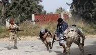 Libyan fighters loyal to the Government of National Accord (GNA) run as they fire their guns during clashes with forces loyal to strongman Khalifa Haftar south of the capital Tripoli's suburb of Ain Zara, on April 20, 2019.  AFP / Mahmud Turkia 