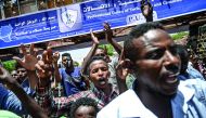 Sudanese protesters flash the V for victory signs as they shout slogans during a protest near the army hearquarters in the capital Khartoum on April 21, 2019. AFP / Ozan Kose 