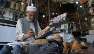 In this picture taken on April 1, 2019, Chacha Noor Din, the owner of a string of shoe stores, makes a pair of sandals at his shop in Peshawar.  AFP / Abdul Majeed