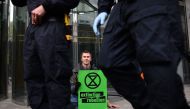 Climate change activists who glued themselves to the pavement block the entrance to the London stock exchange during protests by the Extinction Rebellion group in London on April 25, 2019. / AFP / Ben STANSALL