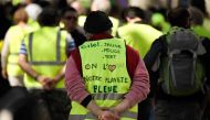 A protester wears a yellow vest on which is written 'yellow, red or green vest, we all love our blue planet', during an anti-government demonstration called by the 'Yellow Vest' (Gilets Jaunes) on April 27, 2019 in Marseille.  AFP / GERARD JULIEN