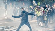 A masked protester dressed in black throws a projectile to riot police officers, prior to the start of May Day demonstrations, in Paris on May 1, 2019.  AFP / Zakaria ABDELKAFI
