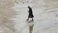 A man walks in a flooded road in the Tunisian coastal governorate of Nabeul on September 23, 2018 following deadly flash flooding in the town of Bir Challouf. AFP/Fethi Belaid