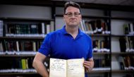 German archivist Stefan Litt displays a guestbook of Moshe Yaakov Ben-Gavriel, bearing the signature of SS officer Leopold von Mildenstein, at the Jerusalem National Library on May 1, 2019.  AFP / Thomas Coex
 