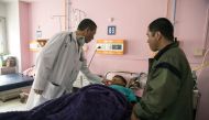 In this photo taken on March 30, 2019, Bhutan's Prime Minister Lotay Tshering (L) treats a patient at the National Referral Hospital in the Bhutanese capital Thimphu. AFP / Upasana Dahal