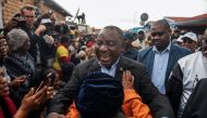 President of South Africa and the African National Congress Cyril Ramaphosa (C) greets a voter as he arrives to cast his vote for the general elections at the Hitekani Primary School, Chiawelo, Soweto, on May 8, 2019. AFP / Michele Spatari