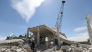 A member of the Syrian Civil Defence (White Helmets) inspect the rubble following shelling by Syrian regime forces and their allies on a the village of Maarit Sin in the countryside of the rebel-held Idlib province on May 11, 2019. / AFP / OMAR HAJ KADOUR