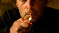 A man smokes in Athens on May 07, 2019.  AFP / Angelos Tzortzinis