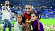 Al Duhail’s Youssef El Arabi celebrates with the trophy. 