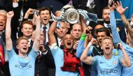 Manchester City's Belgian captain Vincent Kompany (C) lifts the winner's trophy as the players celebrate victory after the English FA Cup final football match between Manchester City and Watford at Wembley Stadium in London, on May 18, 2019.  AFP / Daniel