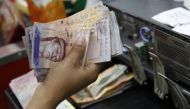 A cashier counts Venezuelan bolivar notes in a state-run supermarket in Caracas January 9, 2015. Reuters / Carlos Garcia Rawlins