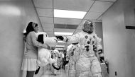 In this May 18, 1969 image obtained from NASA, Apollo 10 Commander Tom Stafford, heading to the Kennedy Space Center launch pad, pats the nose of a stuffed Snoopy held by Jamye Flowers (Coplin), astronaut Gordon Cooper’s secretary.