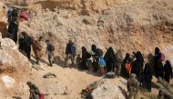 FILE PHOTO: Islamic state fighters and their families walk as they surrender in the village of Baghouz, Deir Al Zor province, Syria March 12, 2019. REUTERS/Rodi Said