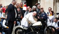 Pope Francis signs a Harley Davidson motorbike of the Christian motorcycle group 