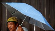 A street vendor uses an umbrella as he waits for customers at a traditional market in Jakarta, Indonesia, June 3, 2019. Reuters/Willy KurniawanAnd a pinch of background.  