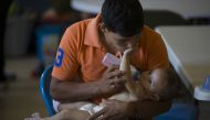 A man feeds his daughter, both originally from Honduras, as the relax at the El Calvario Methodist Church which is housing migrants who are seeking asylum, after they were released by the U.S. Immigration and Customs Enforcement on June 3, 2019 in Las Cru