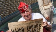 D-Day veteran and former POW Robert Levine, 94, of Teaneck, NJ, holds up a newspaper front page during the 75th anniversary of the D-Day landings in Normandy at the World War II Memorial in Washington, U.S., June 6, 2019. Reuters/Kevin Lamarque