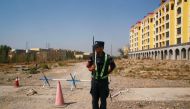 A Chinese police officer takes his position by the road near what is officially called a vocational education centre in Yining in Xinjiang Uighur Autonomous Region, China September 4, 2018. REUTERS/Thomas Peter 
 