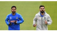 India's Bhuvneshwar Kumar (L) and India's captain Virat Kohli jog during a training session at Old Trafford Cricket Stadium in Manchester on June 15, 2019, ahead of their 2019 World Cup match against Pakistan. AFP / Dibyangshu Sarkar 