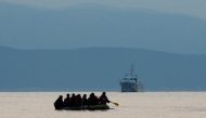 Migrants in a dinghy paddle their way on the Mediterranean Sea to attempt crossing to the Greek island of Kos as a Turkish Coast Guard ship patrols off the shores off Bodrum Sept 19, 2015. Reuters/Umit Bektas