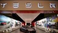 In this file photo taken on February 19, 2014, people look at a Tesla Motors vehicle on the showroom floor at the Dadeland Mall in Miami. AFP/Getty Images North America/Joe Raedle