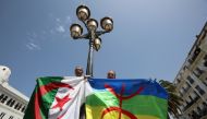 Demonstrators carry Algerian and Amazigh flags during a protest demanding the removal of the ruling elite in Algiers, Algeria June 21, 2019. Reuters/Ramzi Boudina