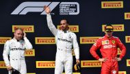 Winner Mercedes' British driver Lewis Hamilton (C) celebrates on the podium next to second placed Mercedes' Finnish driver Valtteri Bottas (L) and third placed Ferrari's Monegasque driver Charles Leclerc (R) after the Formula One Grand Prix de France at t