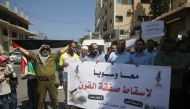 Paletinians hold banners denouncing the US-led Peace to Prosperity conference that opens tomorrow in Bahrain, in Gaza City on June 24, 2019.   AFP / MOHAMMED ABED