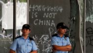 Policemen stand in front of graffiti on the walls of the Legislative Council, a day after protesters broke into the building in Hong Kong, China July 2, 2019. REUTERS/Jorge Silva