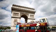 FILE PHOTO: Tourists ride in an open-air double-decker bus past the Arc de Triomphe in Paris, France, May 30, 2017. REUTERS/Charles Platiau/File Photo
 