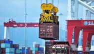 A container is transferred at a port in Qingdao, Shandong province in eastern China on July 6, 2018. (AFP) 