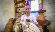 Moroccan potter Aicha Tabiz, also known as Mama Aicha, holds one of her works near the village of Ourtzagh in the foothills of the Rif mountains on June 12, 2019. AFP / FADEL SENNA