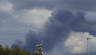 Smoke rises from a fire at an electricity generating power station in Moscow region as a sculpture of 