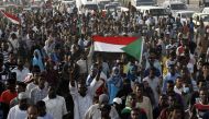 Sudanese protesters raise national flags as they rally in the capital Khartoum to mourn dozens of demonstrators killed last month in a brutal raid on a Khartoum sit-in, on July 13, 2019.(AFP / ASHRAF SHAZLY)